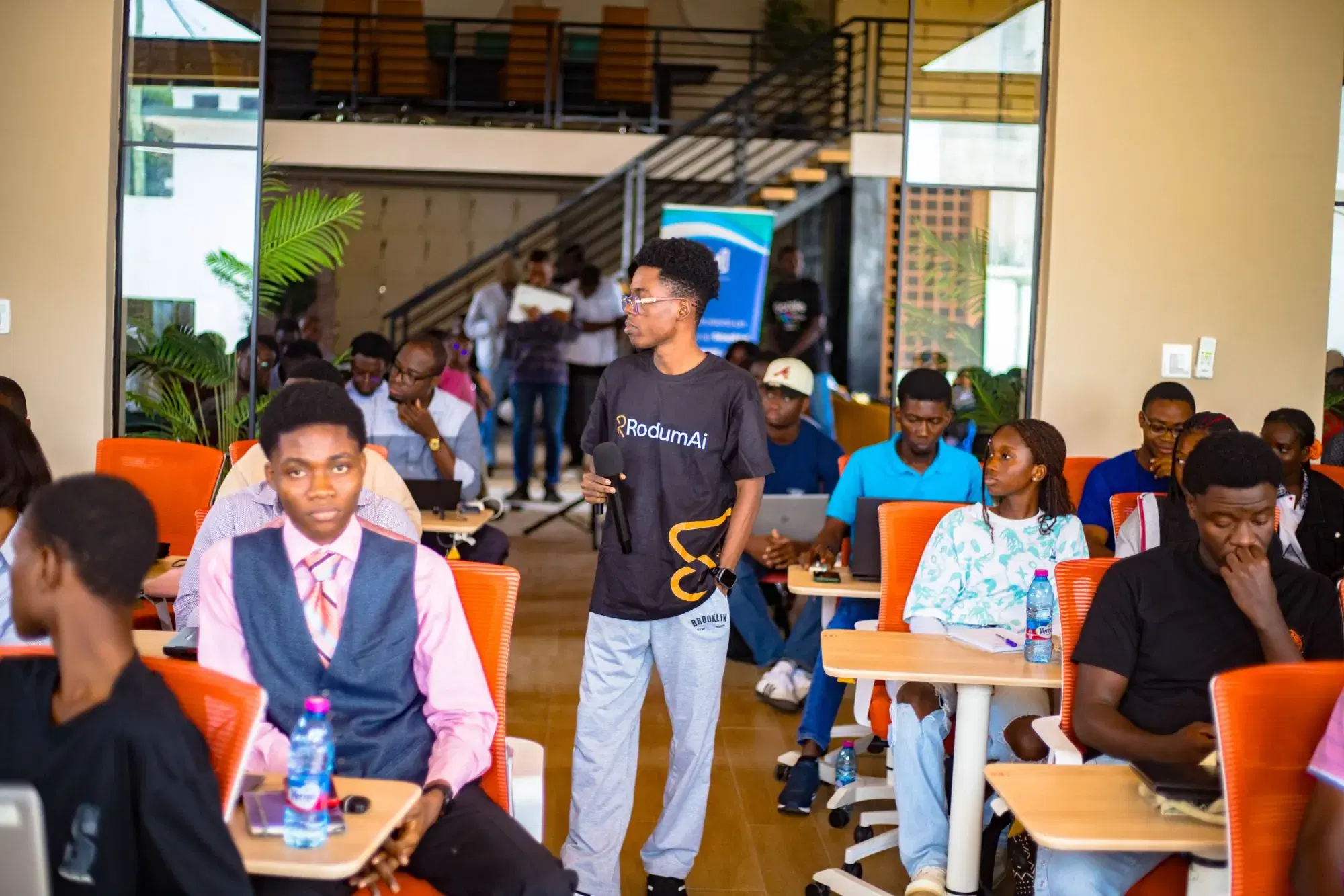 Un formateur RodiumAi circule dans une salle de bootcamp pleine de participants