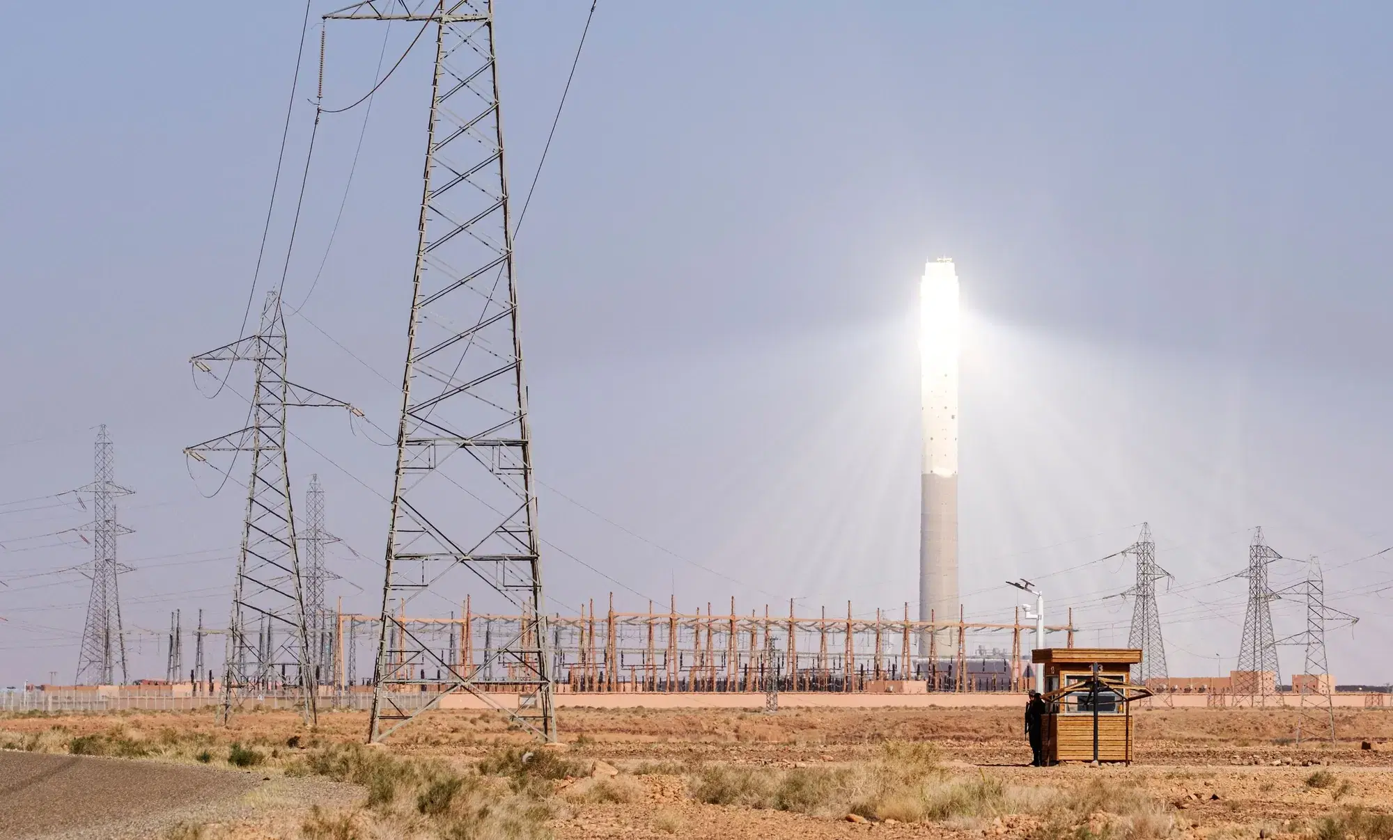 Tour solaire éclatante et lignes à haute tension dans le désert marocain