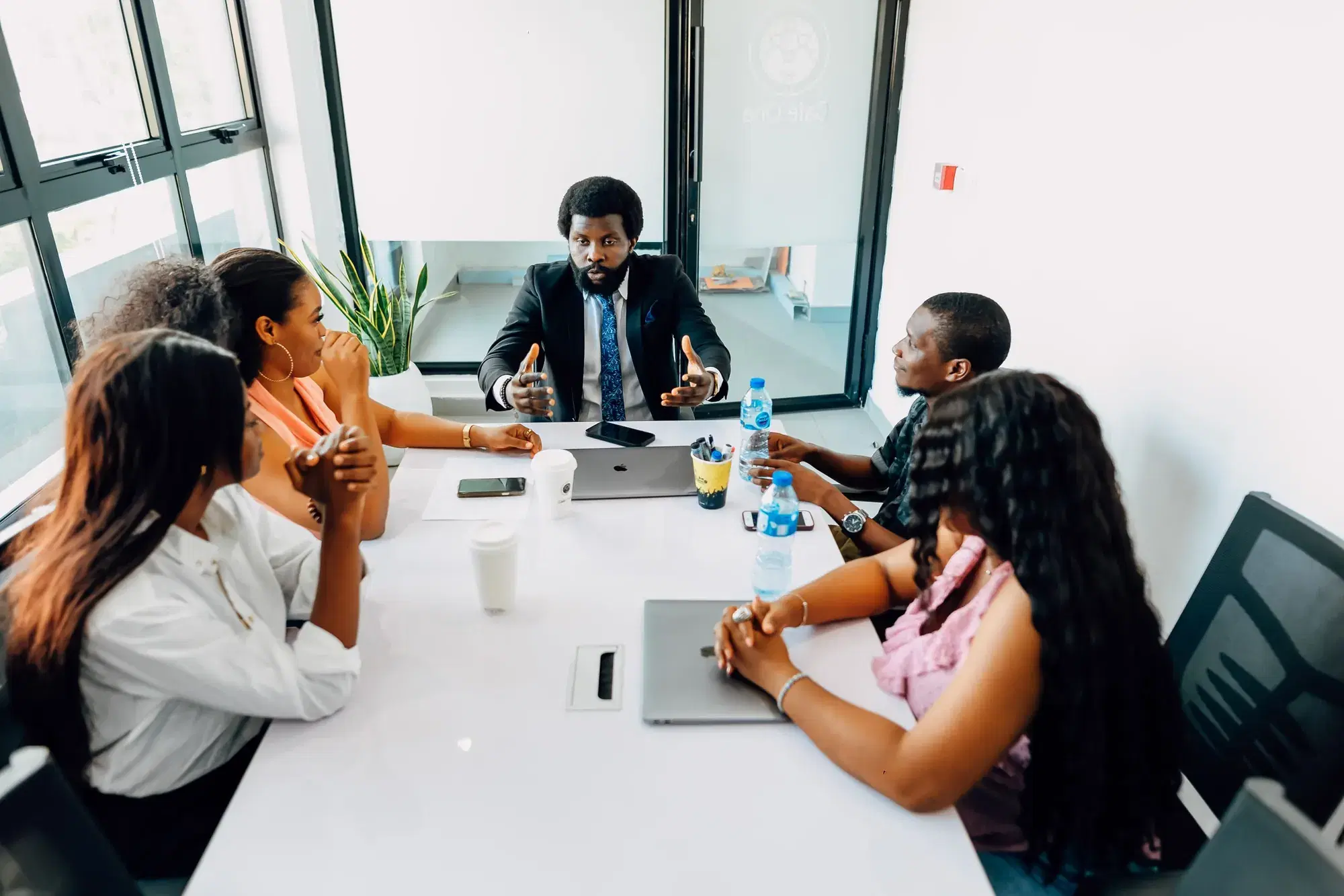 Dirigeant animant une réunion avec ses collaborateurs autour d'une table dans un bureau à Lagos