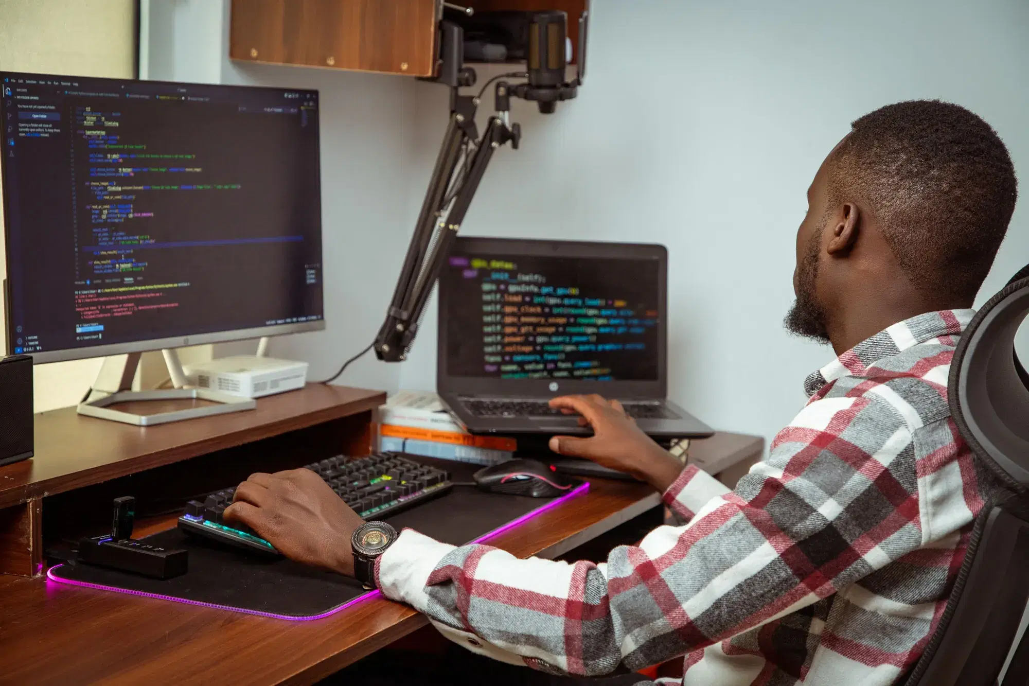 Développeur logiciel écrivant du code sur un écran et un ordinateur portable à Nairobi