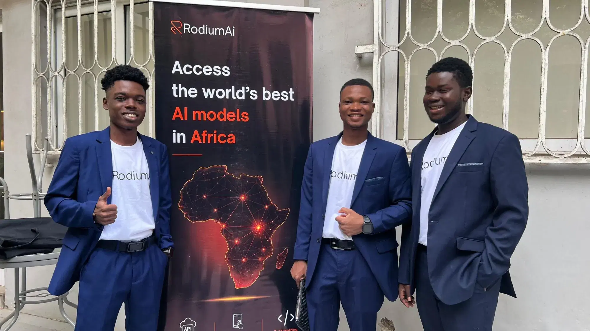 L’équipe RodiumAi pose à côté de sa bannière « Access the world’s best AI models in Africa »